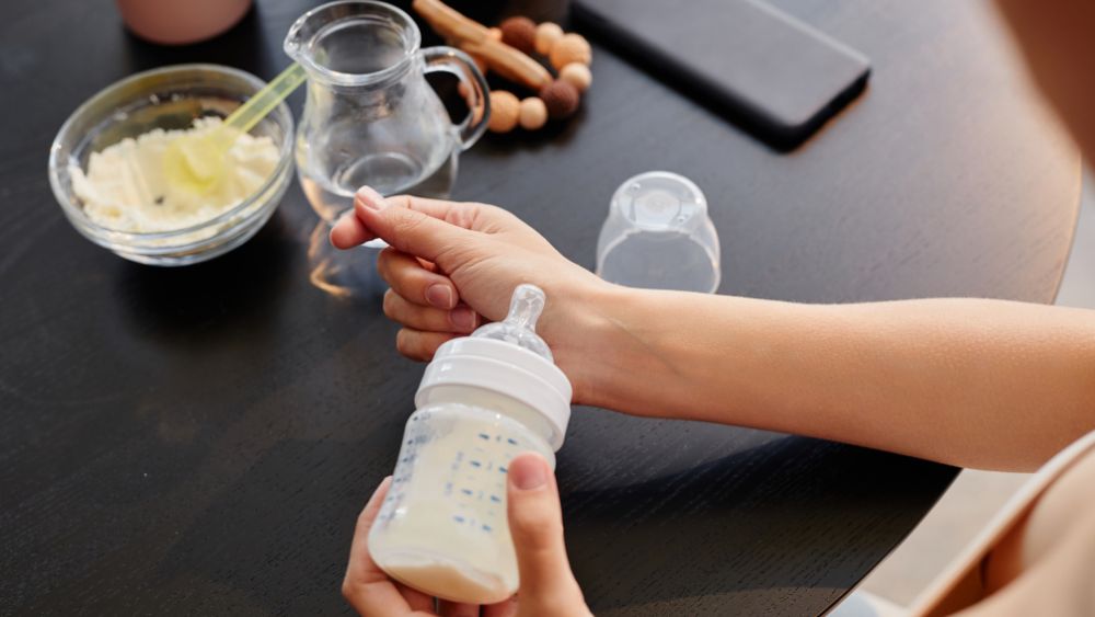 parent making baby bottle